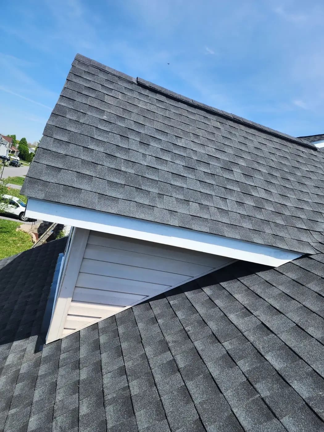 New charcoal architectural shingles finished around a dormer