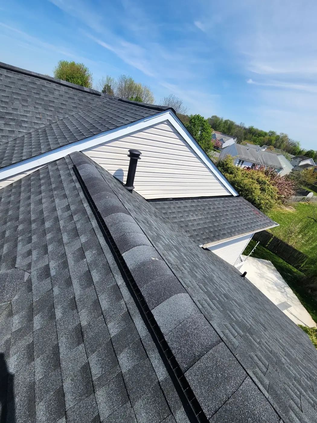 New architectural shingles and ridge cap along a roof line
