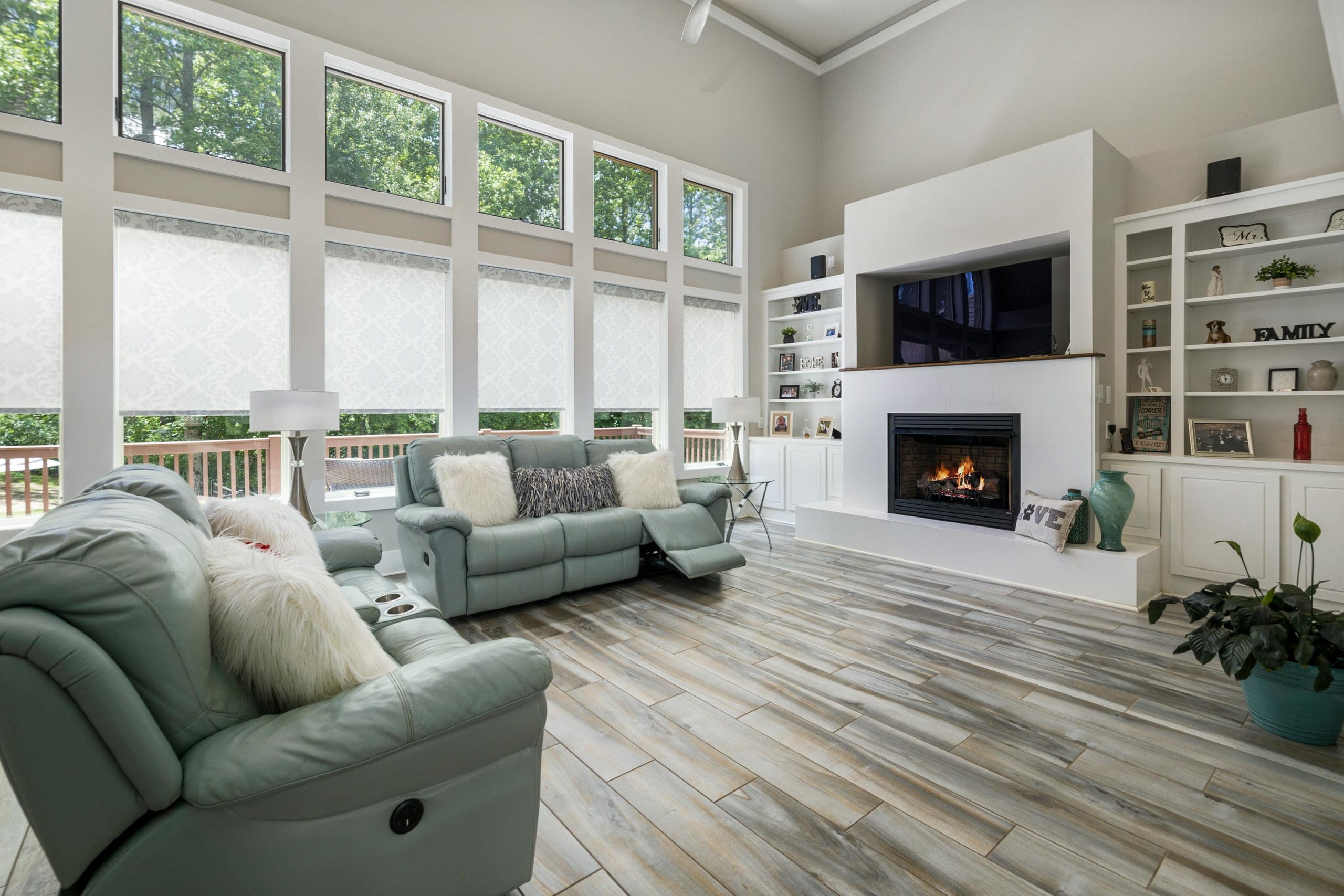 A bright family room with a fireplace and large windows