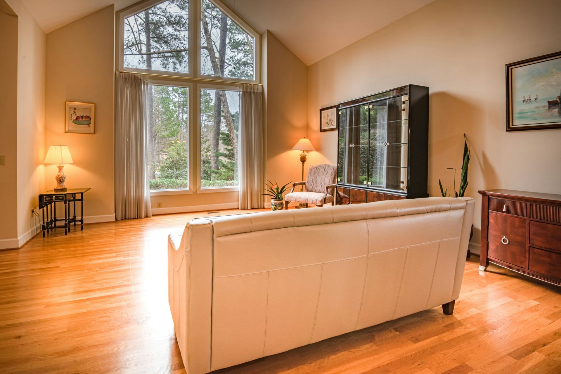 A bright, modern living room with hardwood flooring and large windows
