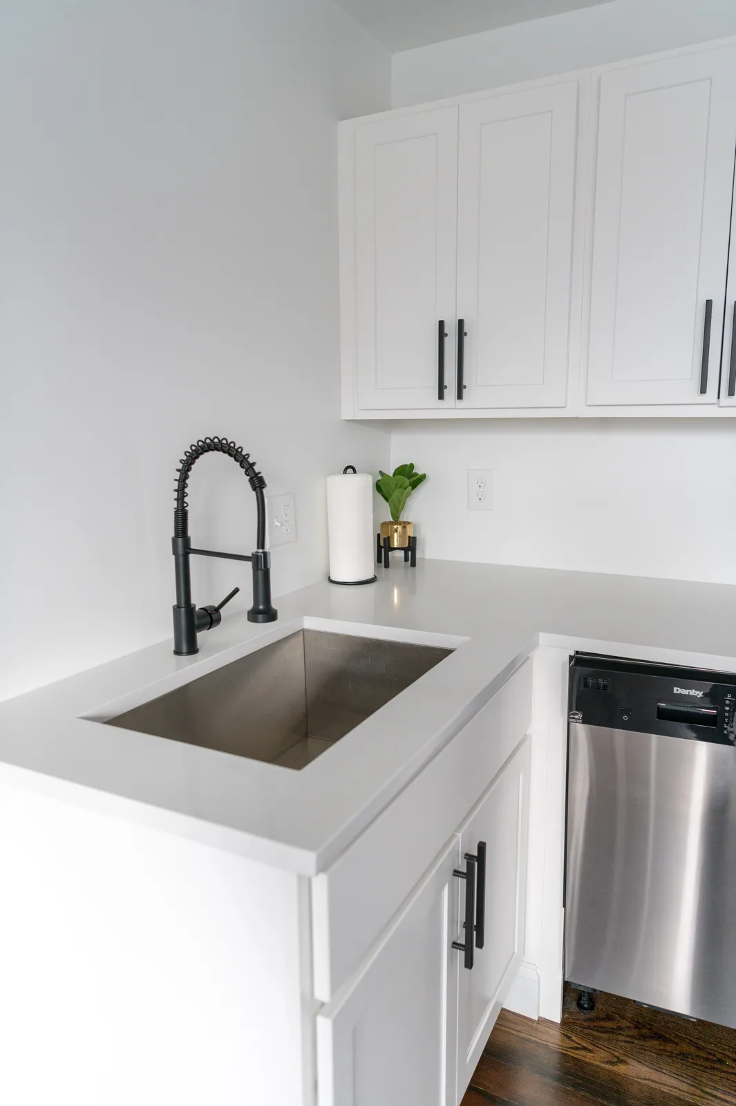 Kitchenette inspiration with white cabinetry, a sink, and a compact refrigerator