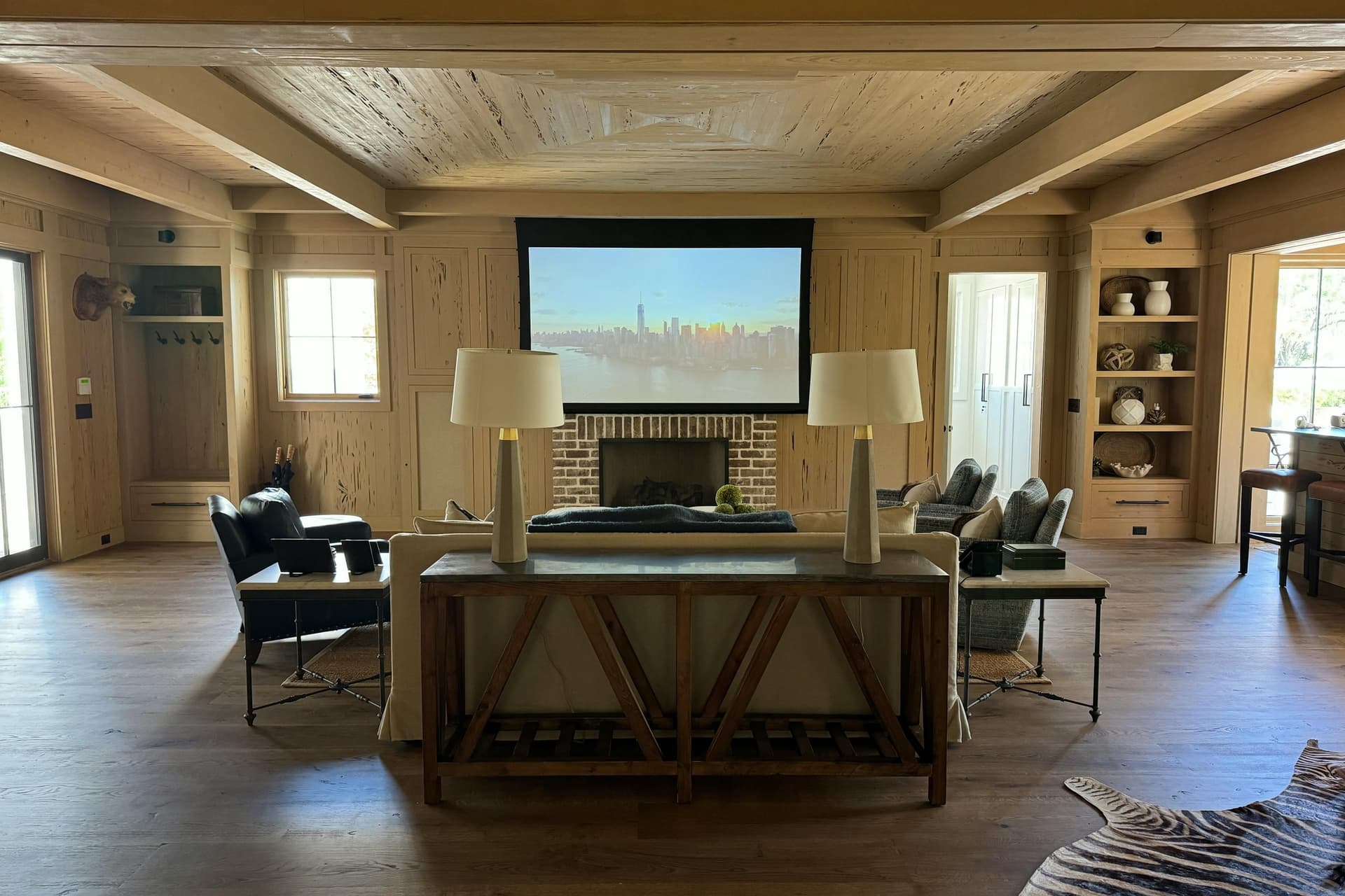 Finished lower level with wood-panelled walls, a projection screen and a fireplace