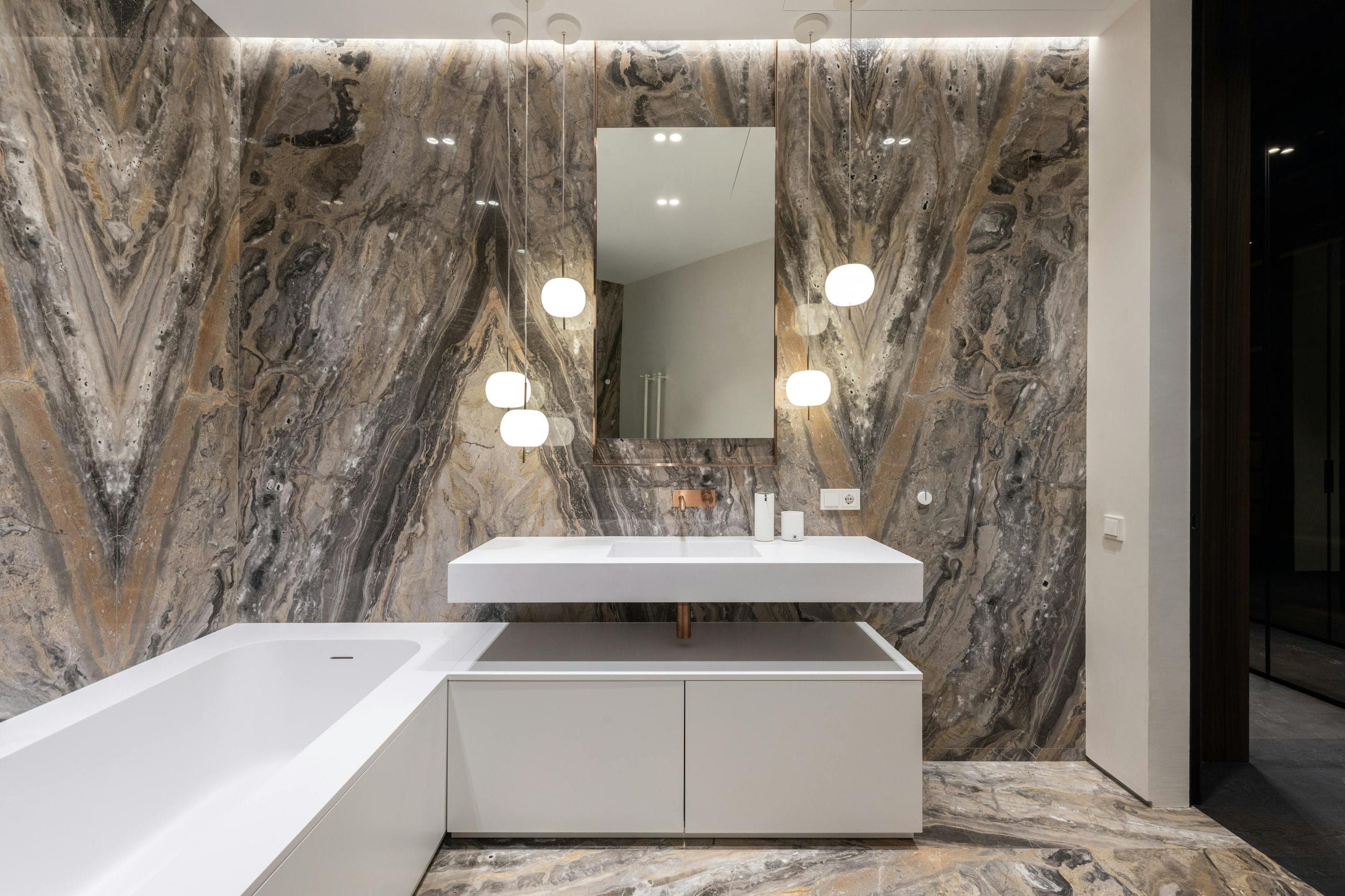 A spa-style primary bathroom with a freestanding soaking tub and frameless glass
