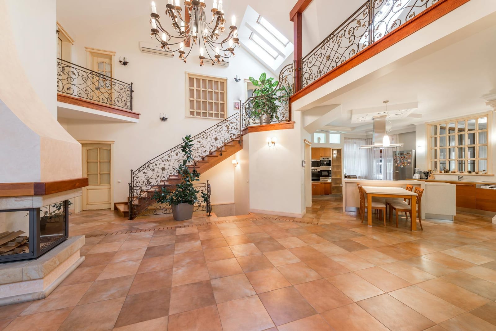 An upscale open-concept kitchen and dining area near a staircase in a bright home