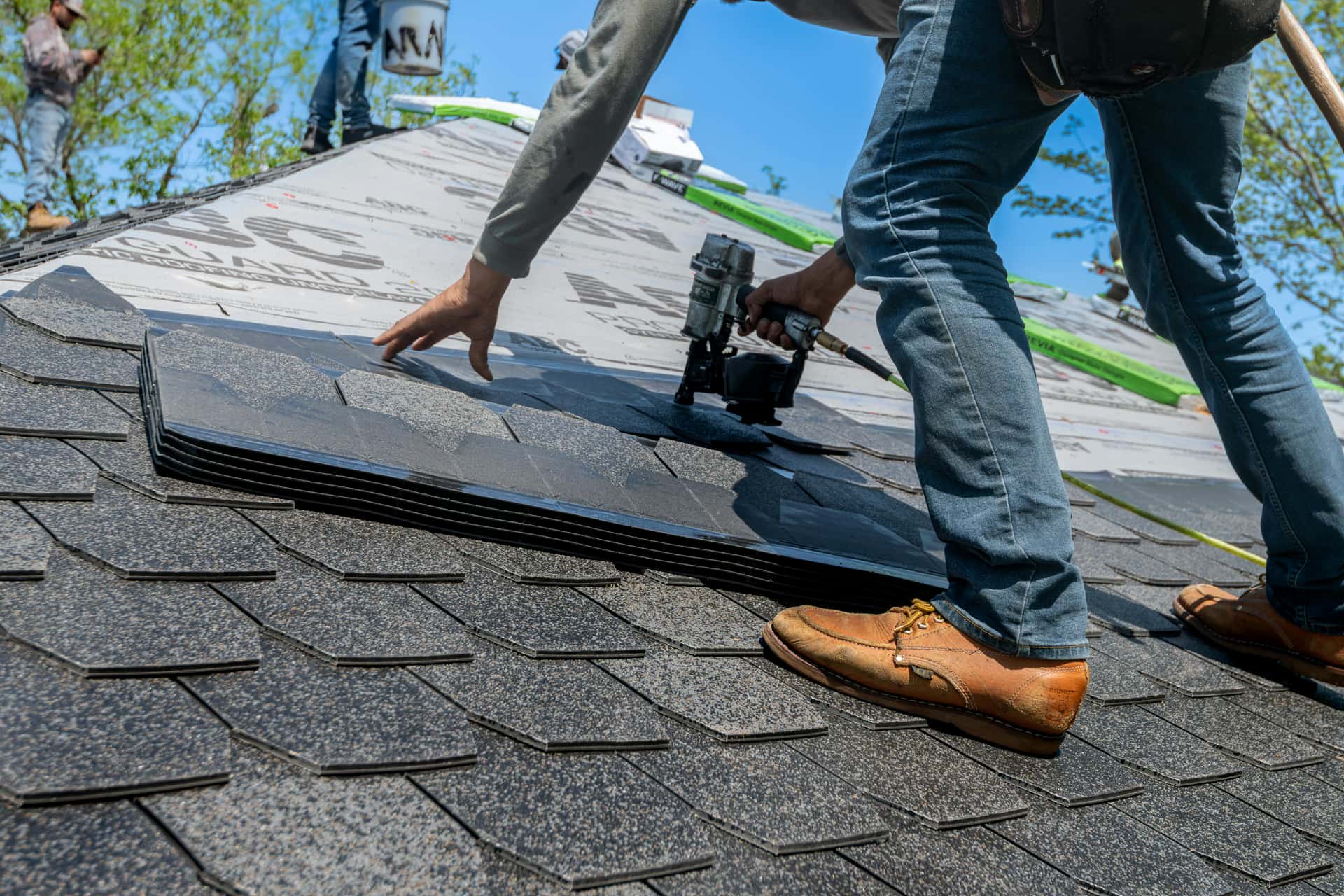 Close-up of architectural shingle install with nail gun