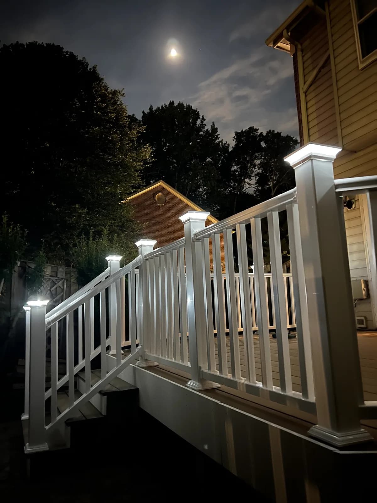 Deck stair and railings lit by post-cap lights at night